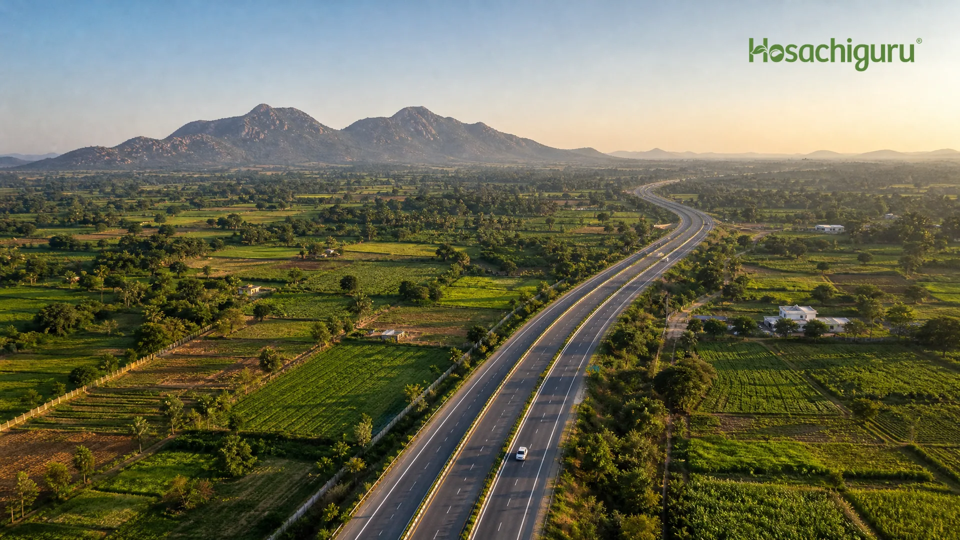 Aerial view of Chikkaballapur green farmland with road infrastructure in the distance